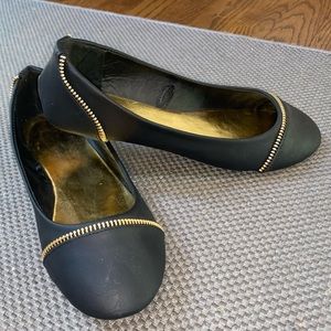 Black flats with gold zipper details